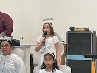 a group of people singing in front of a group of angels