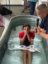 a man is holding a microphone while a woman is in a tub