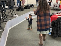 a woman and a child standing in front of a stage