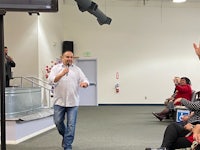 a man is giving a speech to a group of people