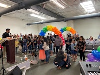 a group of people standing in a room with balloons