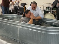 a man and woman are being baptized in a tub