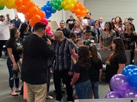 a group of people standing in a room with balloons