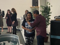 a woman is being baptized in front of a group of people