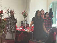 a group of people standing in a room with red and black decorations