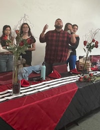 a group of people standing around a table with flowers
