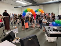 a group of people in a room with a keyboard and balloons
