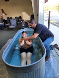 a man is helping a woman get into a tub of water
