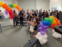 a group of people standing in a room with balloons