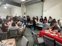 a group of people eating at a table in a room