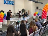 a group of people standing in a room with balloons