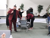 a man in a red suit standing in front of a group of people