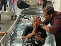 a man is holding a child in a tub of water