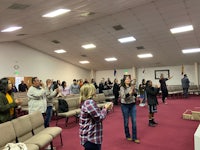 a group of people standing and clapping in a church