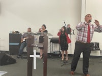 a man singing in front of a group of people