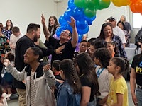 a group of people standing in a room with balloons