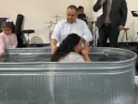 a man and woman are being baptized in a tub