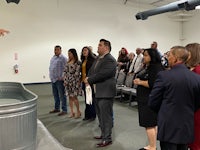 a man in a suit standing in front of a group of people