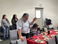 a group of people standing around a table