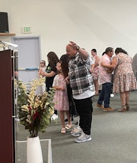 a group of people standing in a room with flowers