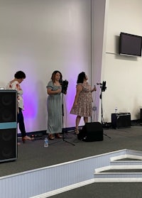 a group of people standing on stage in a church