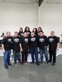 a group of people in black t - shirts posing for a picture