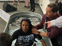 a man is being baptized in a tub