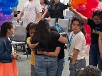 a group of people standing in a room with balloons