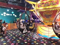 a group of people sitting on a ride at an amusement park