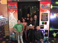 a group of people posing in front of an arcade machine