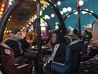 two people sitting in a carousel at an amusement park