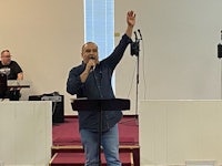 a man standing in front of a microphone in a church