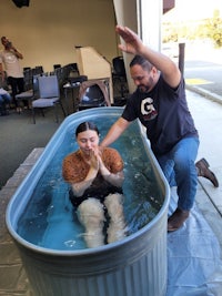 a woman is being baptized in a tub