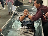 a man is being baptized in a tub