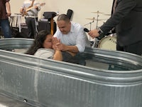 a woman is being baptized in a tub