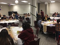 a group of people eating at a table in a room