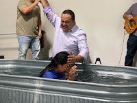 a woman is being baptized by a man in a tub