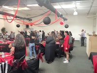 a group of people in a room with red and black decorations
