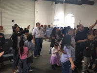 a group of people standing and waving their hands in the air