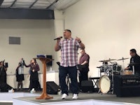 a man singing in front of a group of people