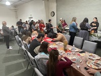 a group of people sitting around a table at a thanksgiving dinner