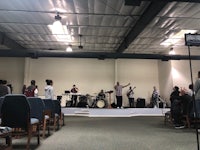 a group of people standing on a stage in a church