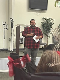 a man giving a speech in front of a group of people