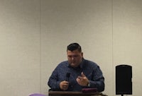 a man giving a speech in front of a microphone