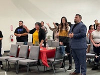 a group of people standing and clapping in a room