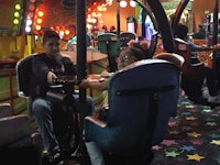 two people sitting in a carousel at an amusement park