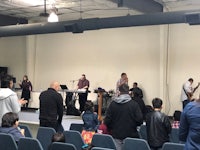 a group of people standing in front of a stage in a church