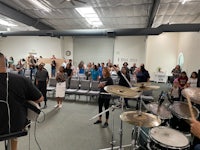 a group of people in a room playing drums