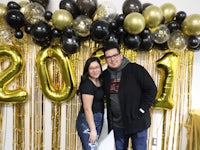 a man and woman standing in front of balloons with the year 2019 written on them