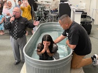 a woman is being baptized in a tub